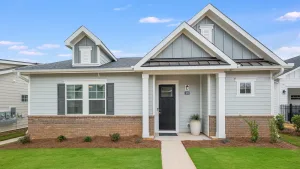 Photo of front elevation of home with private front porch and a grass lawn. New pet-friendly apartment homes for rent with private fenced backyards in Monroe, NC, near Charlotte, NC with pool, dog park, gym, and gated community. *No breed or weight restrictions.