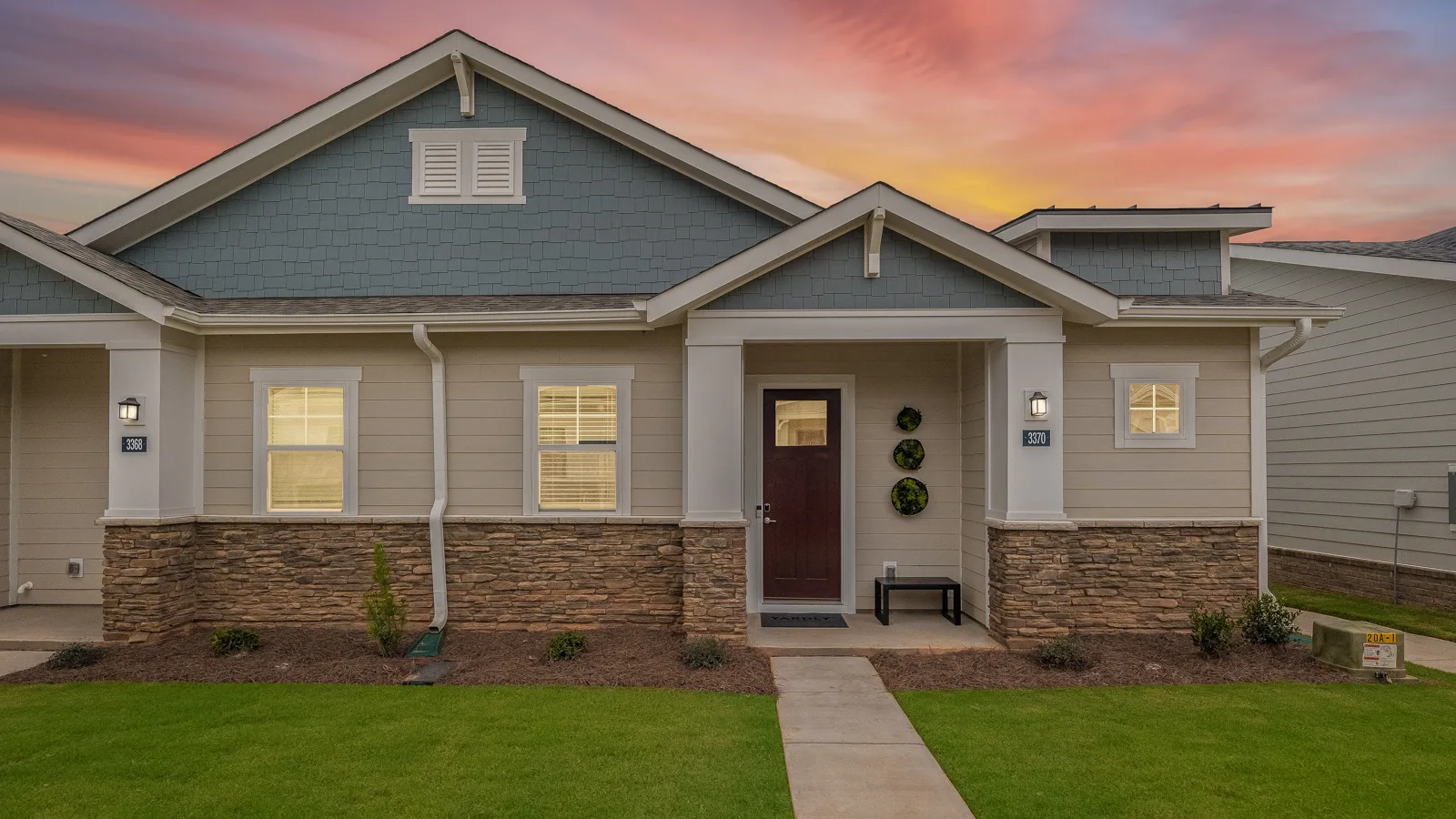 Photo of front elevation of home with private front porch and a grass lawn. New pet-friendly apartment homes for rent with private fenced backyards in Monroe, NC, near Charlotte, NC with pool, dog park, gym, and gated community. *No breed or weight restrictions.