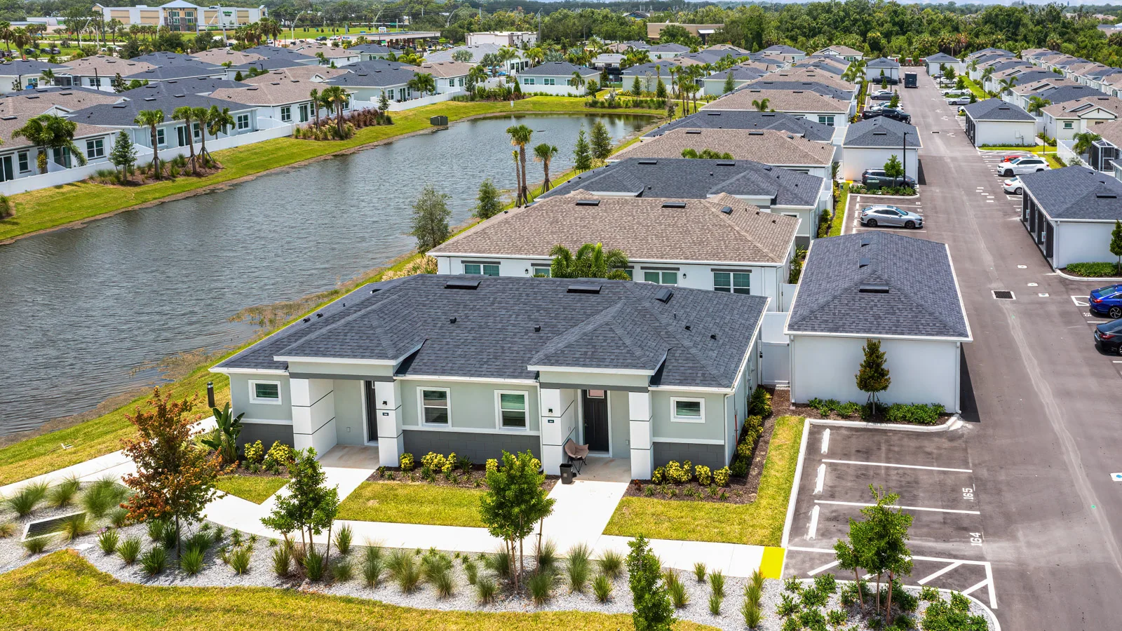 Artisan lakes arial community shot with pond in the middle. New pet-friendly apartment homes for rent with private fenced backyards Arizona, Texas, Florida, and North Carolina with pool, pickleball, dog park, gym, clubhouse and gated community. *No breed or weight restrictions.