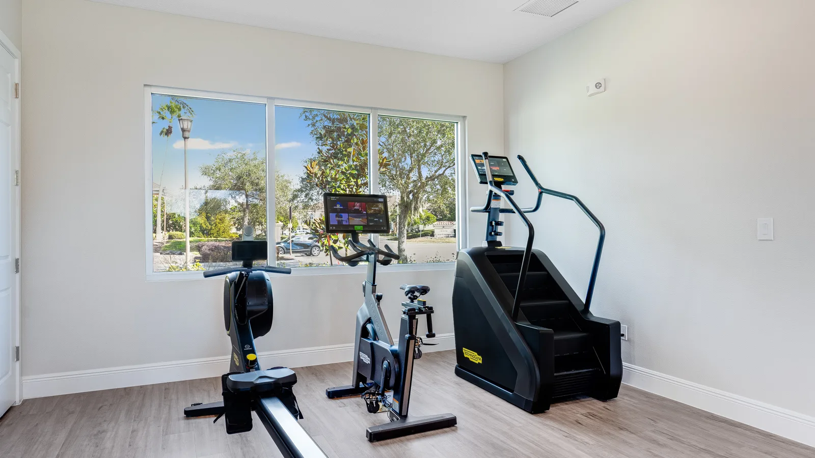 Community apartment gym with stair stepper bike, and rower, as well as lifting equipment and assisted machines. New pet-friendly apartment homes for rent with private fenced backyards in Kissimmee, FL, near Orlando, FL with pickle ball, dog park, gym, and gated community. *No breed or weight restrictions. Yardly Bellalago