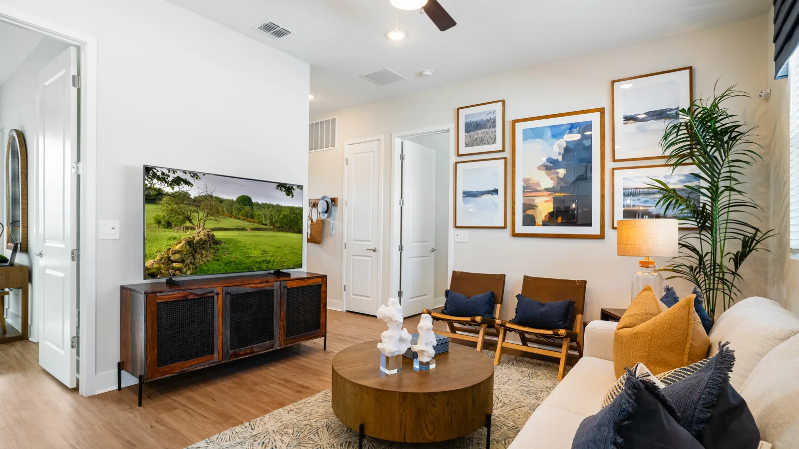 Photo of living from kitchen. Sofa couch with double sideboard and two chairs along with an end table and coffee table with a coastal modern touch of decor. New pet-friendly apartment homes for rent with private fenced backyards in Kissimmee, FL, near Orlando, FL with pickle ball, dog park, gym, and gated community. *No breed or weight restrictions. Yardly Bellalago